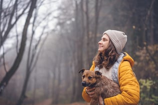 woman-with-dog-in-forest-2021-12-09-14-51-00-utc
